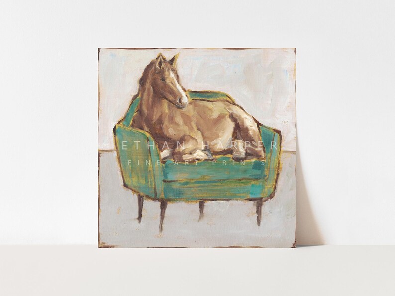 May include: A painting of a brown horse lying on a teal green velvet armchair with gold accents. The background is a light beige color.