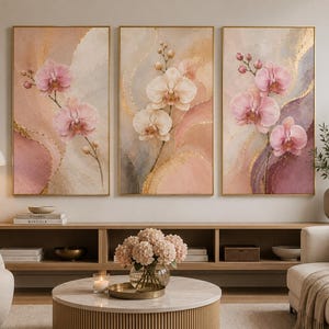 Puede incluir: Un conjunto de tres cuadros verticales que presentan flores de orquídeas rosas y blancas sobre fondos abstractos de acuarela en tonos rubor, malva y crema, realzados con delicados detalles de pan de oro en cada lienzo.