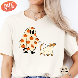 a woman wearing a t - shirt with a ghost and dog on it