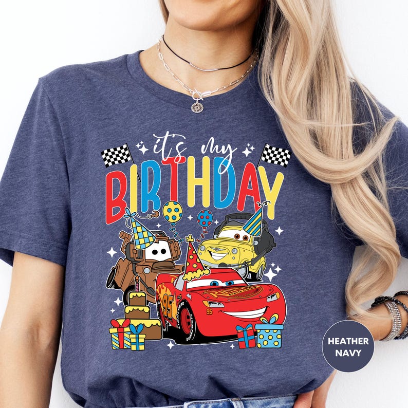 a woman wearing a birthday shirt with cars on it