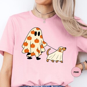 a woman wearing a pink shirt with a dog on it