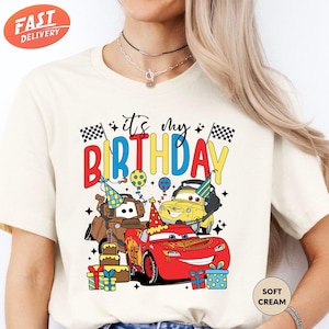 a woman wearing a birthday shirt with cars on it