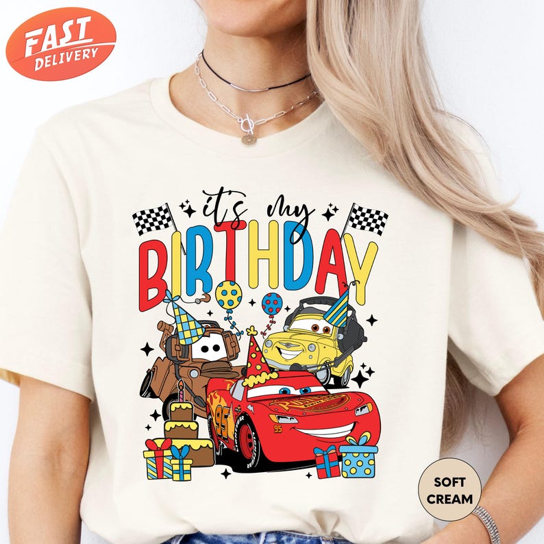 a woman wearing a birthday shirt with cars on it