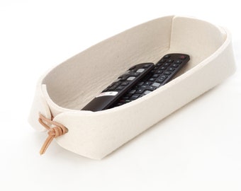 Remote control holder with leather ties in white and grey wool felt.