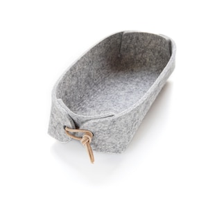 Grey remote control caddy  in pure wool felt with leather toggles.