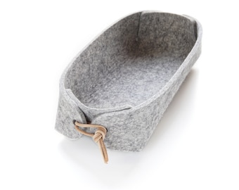 Grey remote control caddy  in pure wool felt with leather toggles.