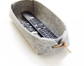 Remote control holder with leather ties in cream white and gray wool felt.