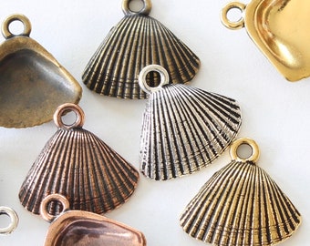 May include: A collection of seashell-shaped metal charms in various finishes, including bronze, copper, silver, and gold. Each charm features a textured, fan-like design and a small loop for attaching to jewelry or other crafts.