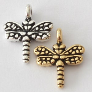 May include: Two dragonfly charms, one silver-toned and one gold-toned, are displayed against a white background. The charms feature detailed wings and segmented bodies, perfect for jewelry making or crafting projects.