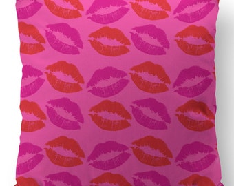 Op de afbeelding: Een roze kussen met een herhalend patroon van rode en roze lippen.