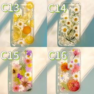 Op de afbeelding: Vier transparante telefoonhoesjes met bloemen- en fruitontwerpen. E&eacute;n hoesje heeft citroenschijfjes en kleine sinaasappels. Een andere heeft witte madeliefjes. Een derde heeft roze, paarse en gele bloemen. De laatste heeft oranje en rode bloemen.