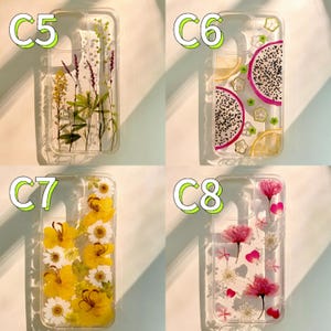 Op de afbeelding: Vier transparante telefoonhoesjes met verschillende ontwerpen. E&eacute;n hoesje heeft gedroogde bloemen, een ander drakenfruit en citroenschijfjes, een derde gele bloemen en de laatste roze bloemen en bloemblaadjes.
