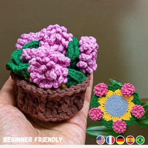 May include: Crocheted flower pot with pink flowers and green leaves. Next to it is a crocheted coaster with pink flowers, yellow petals, and a blue center. The text "BEGINNER FRIENDLY" is at the bottom.