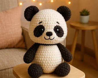 May include: A handmade crochet panda bear with black and white coloring. The panda has black eyes, ears, arms, and legs, with a white body and head. The panda is sitting on a small wooden stool.