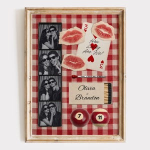 Peut inclure: Un collage encadré sur un fond vichy rouge et blanc comprenant une bande photo en noir et blanc de deux personnes, une carte à jouer avec le texte How Lucky Are We, deux empreintes de lèvres rouges, une boîte d'allumettes Olivia & Brandon et des billes 7 et 11.