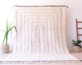 Alfombra bereber de lana blanca tejida a mano, con líneas concéntricas en relieve, estilo Beni Ourain.