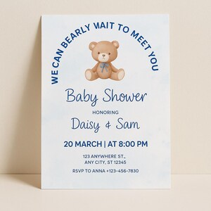 May include: A baby shower invitation with a light blue background and navy blue text. The invitation features a teddy bear illustration and the text "We can bearly wait to meet you." It also includes the names Daisy & Sam, date, time, and address.