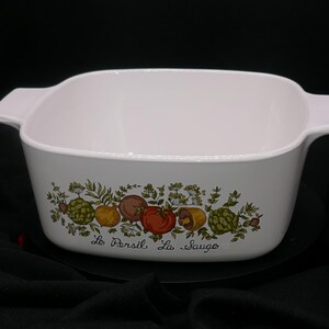 May include: White ceramic baking dish with a green and brown floral design featuring a row of vegetables and the text "Le Persil La Sauge".