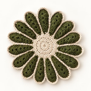 Puede incluir: Un posavasos de ganchillo circular con forma de flor, con un centro beige y doce pétalos de color verde oliva oscuro. Cada pétalo está delineado con un fino borde beige, creando un contraste marcado con la textura del hilo verde oscuro.