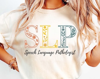 May include: A white t-shirt with the letters "SLP" in floral designs in shades of pink, yellow, and green. The text "Speech Language Pathologist" is printed below the letters.