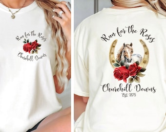 May include: White t-shirt with a graphic design featuring a horseshoe, roses, and a horse's head. The text "Run for the Roses" and "Churchill Downs Est. 1875" is printed on the shirt.
