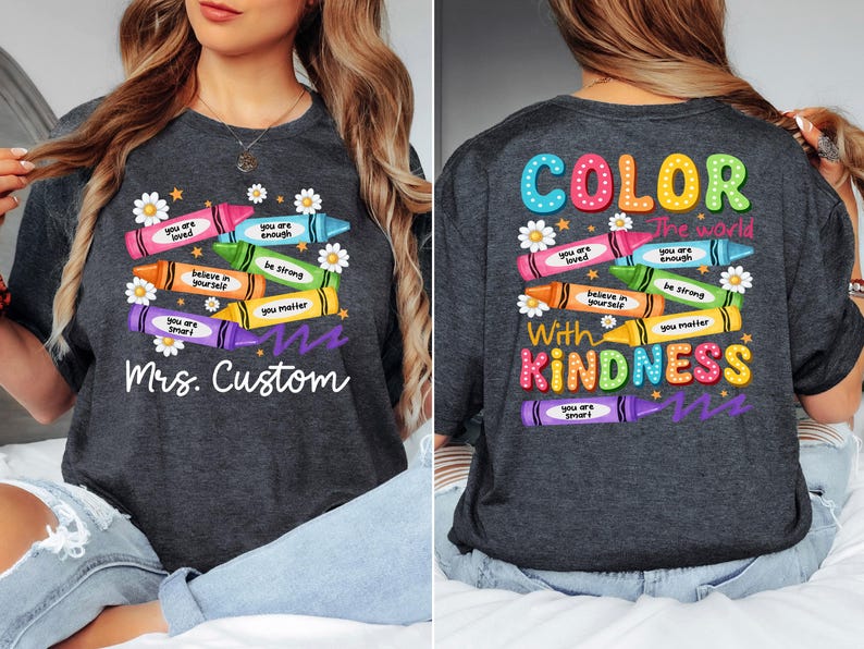 K&ouml;nnte beinhalten: Dunkelgraues T-Shirt mit einem bunten Buntstift-Design. Auf der Vorderseite steht "Mrs. Custom" und Buntstifte mit positiven Botschaften. Auf der R&uuml;ckseite steht "Color the world with kindness."