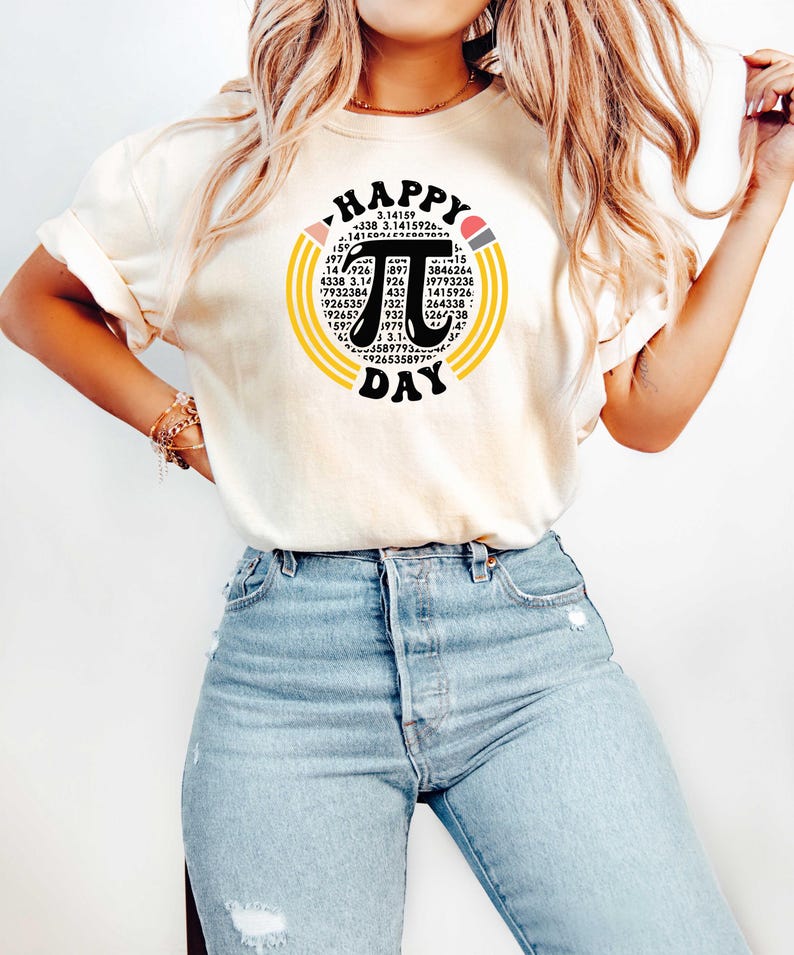 May include: A white t-shirt with a graphic of a black pi symbol surrounded by yellow and orange circles. The graphic also includes the text "HAPPY PI DAY" and a series of numbers.