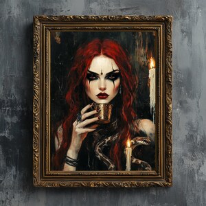 Puede incluir: Una pintura de una mujer con el pelo largo y rojo, vestida con un vestido oscuro y sosteniendo una copa dorada. Lleva maquillaje oscuro y una serpiente envuelta alrededor de su cuello. Dos velas están encendidas en el fondo.