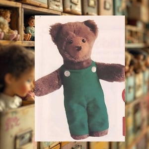May include: A vintage brown teddy bear wearing green overalls with white buttons. The bear has a classic design with a stitched nose and button eyes. The background features a collection of antique dolls.