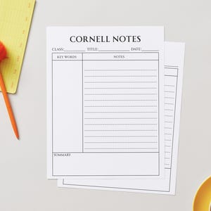 May include: White Cornell Notes sheets with a pen and notepad. The sheets have sections for class, title, date, key words, notes, and a summary. An orange pen with a fluffy top rests on a yellow notepad.