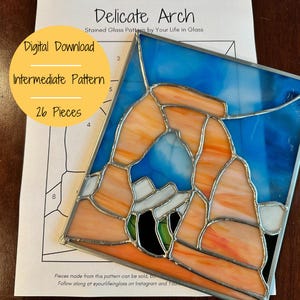 May include: A stained glass pattern of Delicate Arch, a natural sandstone arch in Arches National Park, Utah. The pattern is made up of 26 pieces and is labelled as an intermediate pattern. The pattern is available as a digital download.