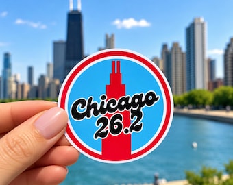 Puede incluir: Una pegatina circular con una silueta roja de la Willis Tower centrada sobre un fondo azul claro, rodeada por un borde rojo y blanco. El texto Chicago 26.2 está impreso en negro con un contorno blanco en el centro del diseño.