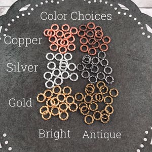 Puede incluir: Surtido de pequeños anillos de metal retorcidos en cobre, plata y oro. Los anillos están etiquetados como "Cobre", "Plata" y "Oro" con las palabras "Brillante" y "Antiguo" debajo. Los anillos están disponibles en acabados brillantes y antiguos.