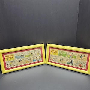 May include: Two framed Beetle Bailey comic strips. Each frame has a yellow border, a red mat, and a series of comic panels. The Beetle Bailey logo is visible in the upper left corner of each frame.