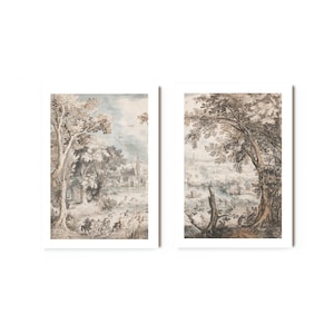 May include: Two framed landscape prints. Each print features a detailed pen and ink drawing of a European village scene with trees, figures, and buildings. The artwork is in shades of brown, gray, and white, with a touch of blue in the sky.