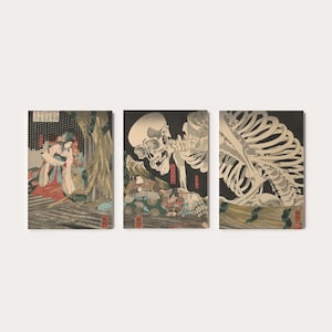 May include: Set of three art prints featuring Japanese woodblock prints. The prints depict scenes with figures and a skeleton, rendered in muted tones of beige, red, and black. The artwork has a vintage aesthetic.