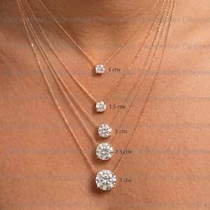 May include: Several rose gold necklaces, each with a clear, round gemstone pendant. The pendants are different sizes, with labels showing the carat weight: 1 ctw, 1.5 ctw, 2 ctw, 2.5 ctw, and 3 ctw.
