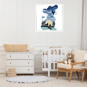 Op de afbeelding: Een blauwe en witte silhouet van een leeuw met een zonsondergang en andere dieren in de silhouet. De afbeelding is ingelijst en hangt aan een witte muur.