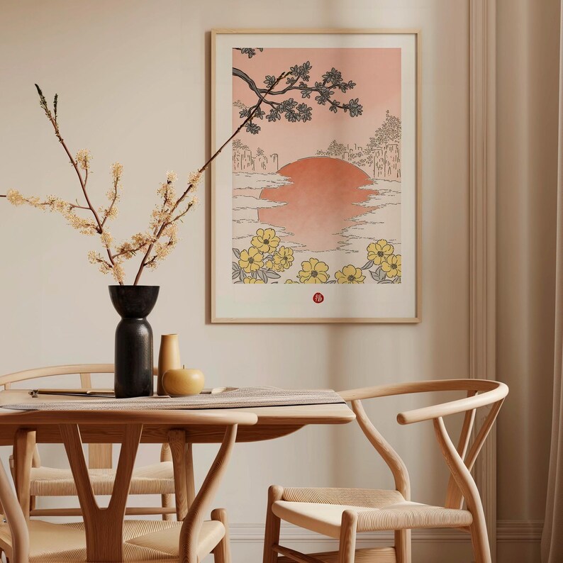 Puede incluir: Una impresi&oacute;n enmarcada de una ilustraci&oacute;n de estilo japon&eacute;s que representa una puesta de sol sobre un paisaje con un &aacute;rbol y flores. La impresi&oacute;n est&aacute; en un marco de madera claro y est&aacute; colgada en una pared de color beige claro.
