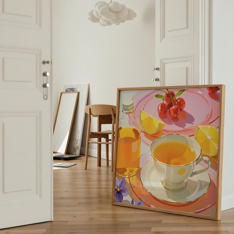 May include: A framed artwork depicts a still life with a teacup, cherries, and a bottle of juice. The artwork features a light wood frame and is set against a light-colored wall. The color palette includes shades of pink, yellow, and orange.