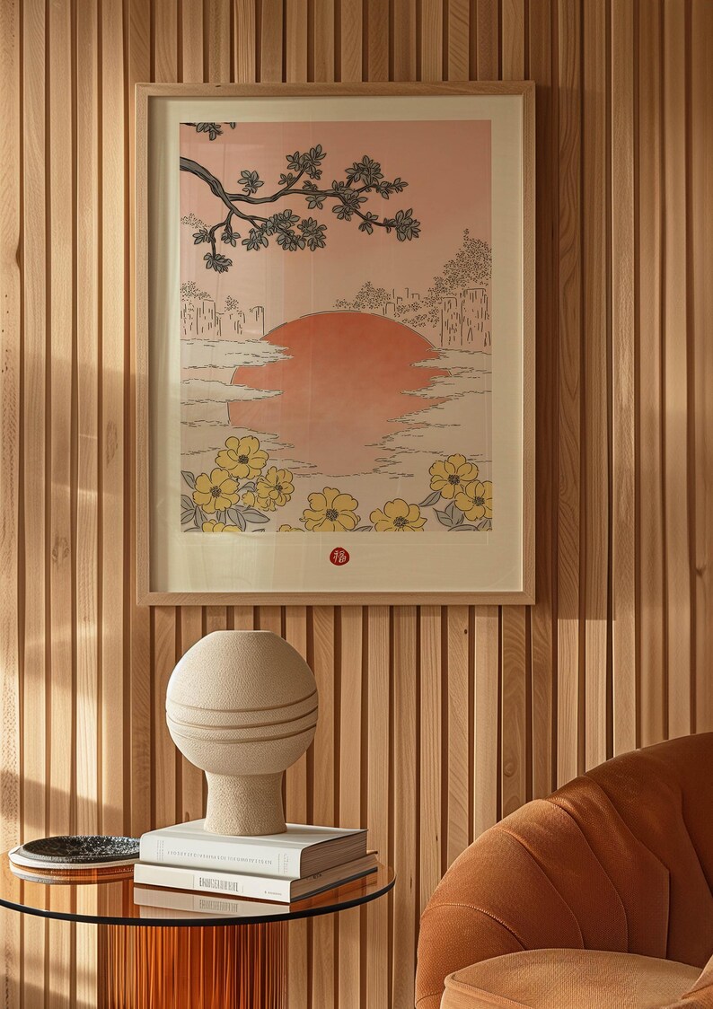 Puede incluir: Una impresi&oacute;n enmarcada de un paisaje de estilo japon&eacute;s con un gran sol rojo, un &aacute;rbol con hojas verdes y flores amarillas en primer plano. La impresi&oacute;n est&aacute; colgada en una pared con paneles de madera.