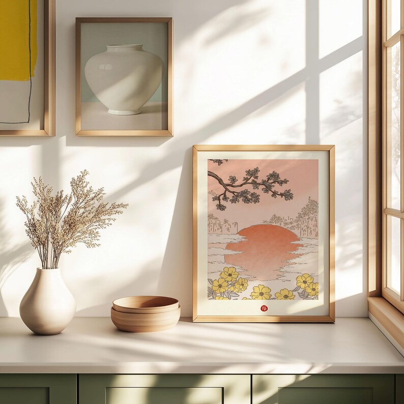 Puede incluir: Una impresi&oacute;n enmarcada de una ilustraci&oacute;n de estilo japon&eacute;s que representa una puesta de sol sobre un lago con una rama de &aacute;rbol y flores amarillas en primer plano.