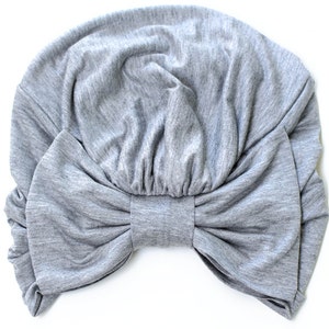 May include: Gray fabric turban with a large bow in the front.