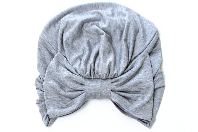May include: Gray fabric turban with a large bow in the front.