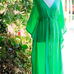 Puede incluir: Una larga kaft&aacute;n verde brillante, fluida, con cuello en V y cintura con cord&oacute;n.