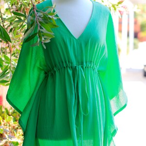 Puede incluir: Una kaftan de color verde brillante, ligera y holgada, con cuello en V y cintura con cord&oacute;n.