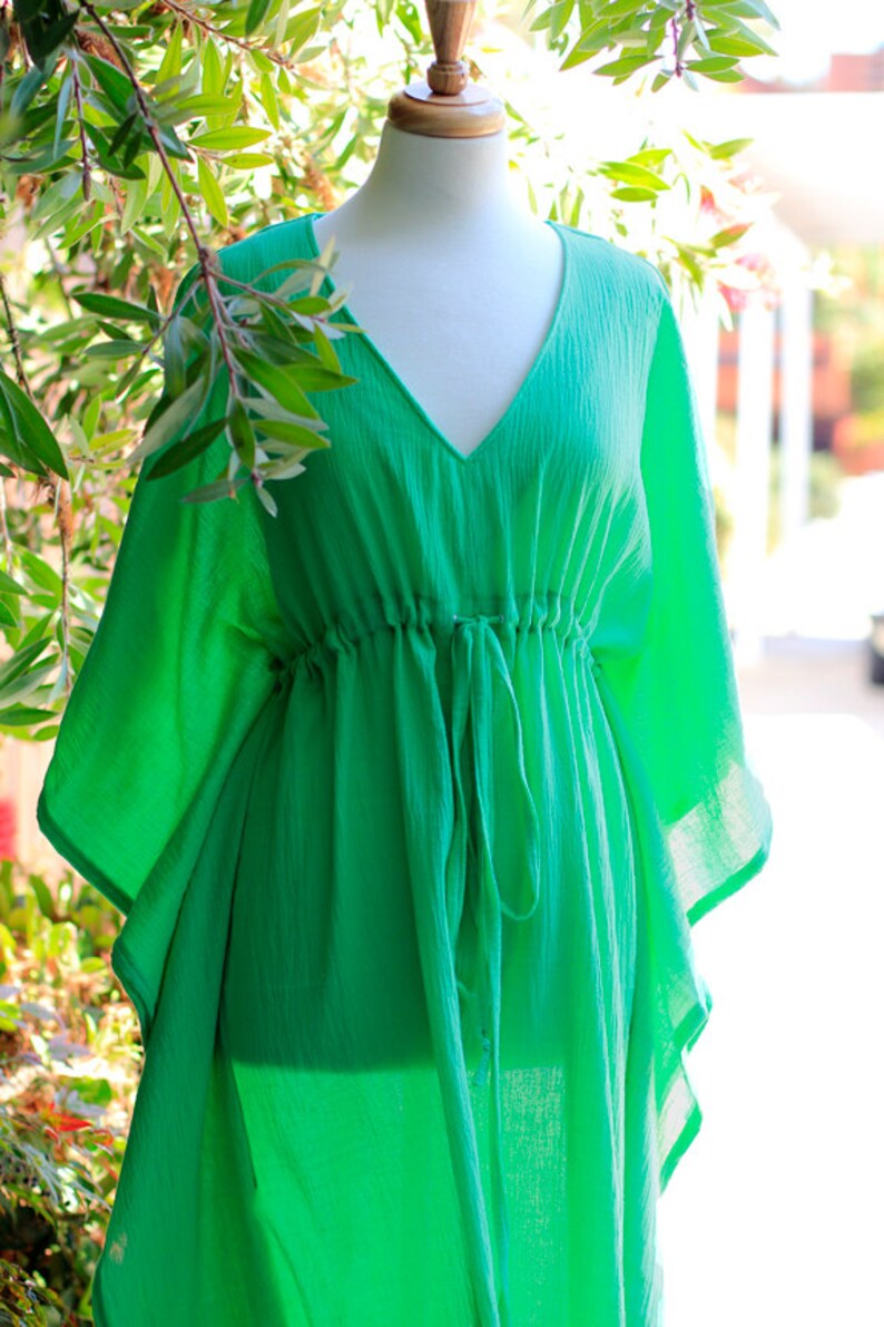 Puede incluir: Una kaftan de color verde brillante, ligera y holgada, con cuello en V y cintura con cord&oacute;n.