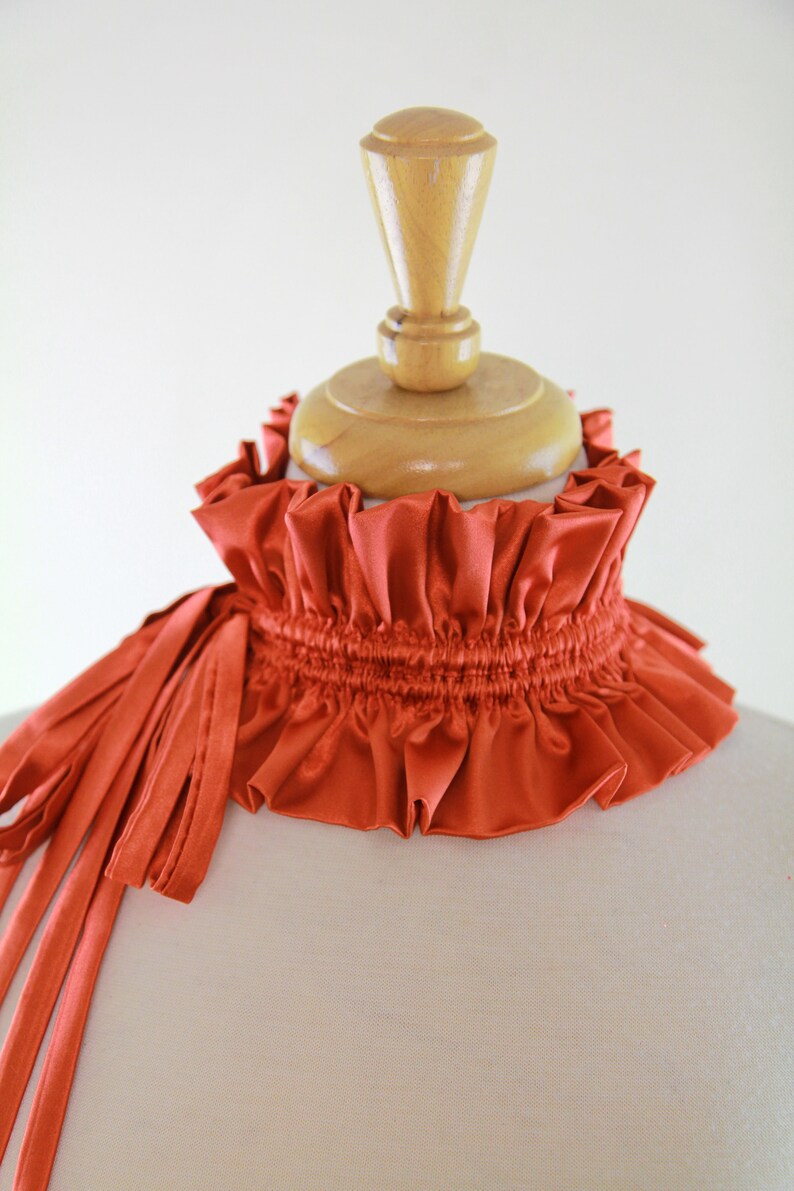 May include: A rust-colored satin choker with a gathered ruffle and a long, flowing tie.