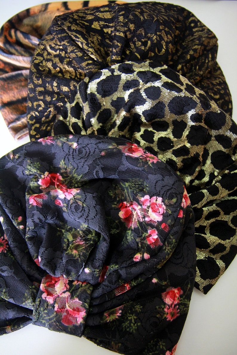 Puede incluir: Tres cintas para la cabeza de tela apiladas. La cinta superior es negra con estampado de leopardo dorado, la cinta del medio es negra con estampado de animal dorado y negro, y la cinta inferior es negra con estampado floral.