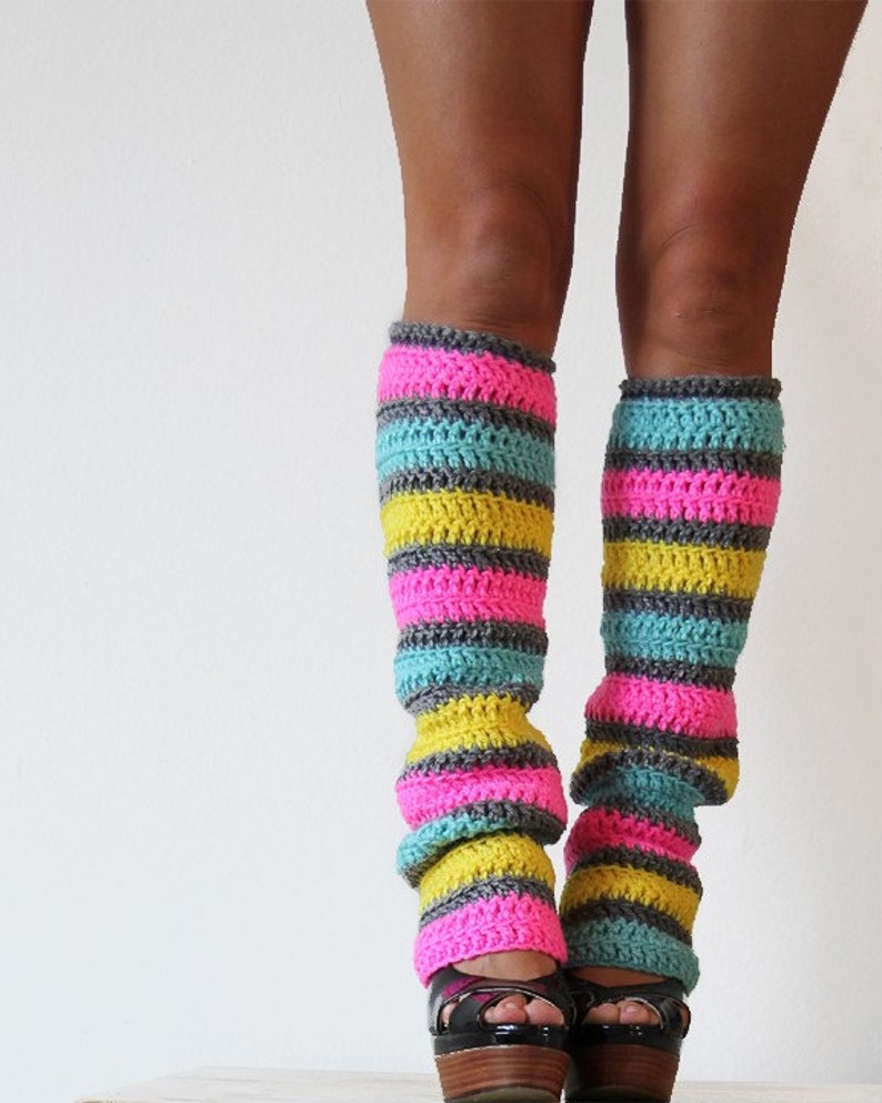 May include: A pair of colorful striped leg warmers in pink, yellow, and blue. The leg warmers are crocheted and have a textured look.